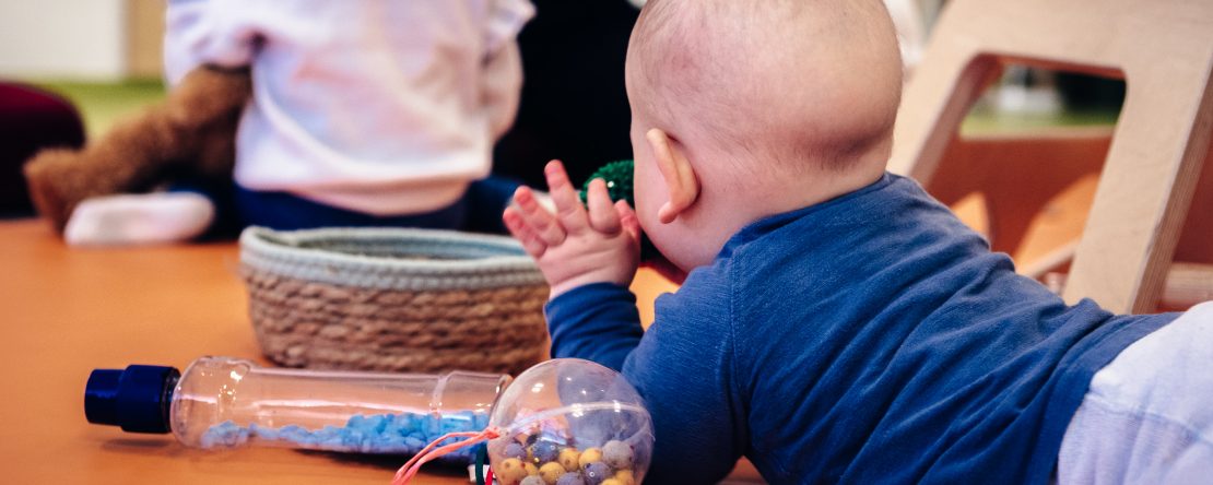Kind krabbelt zwischen Spielzeug