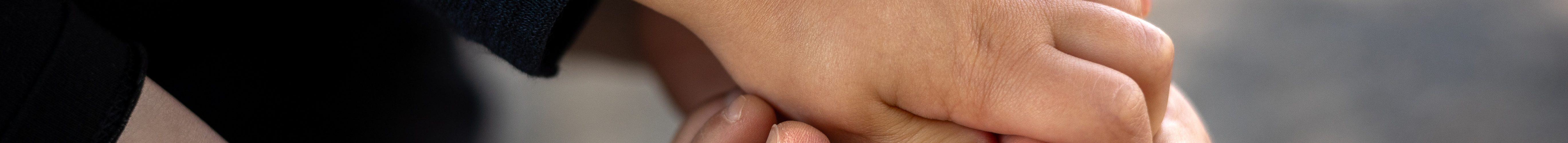 Hand der Mutter und Füsse berühren sich