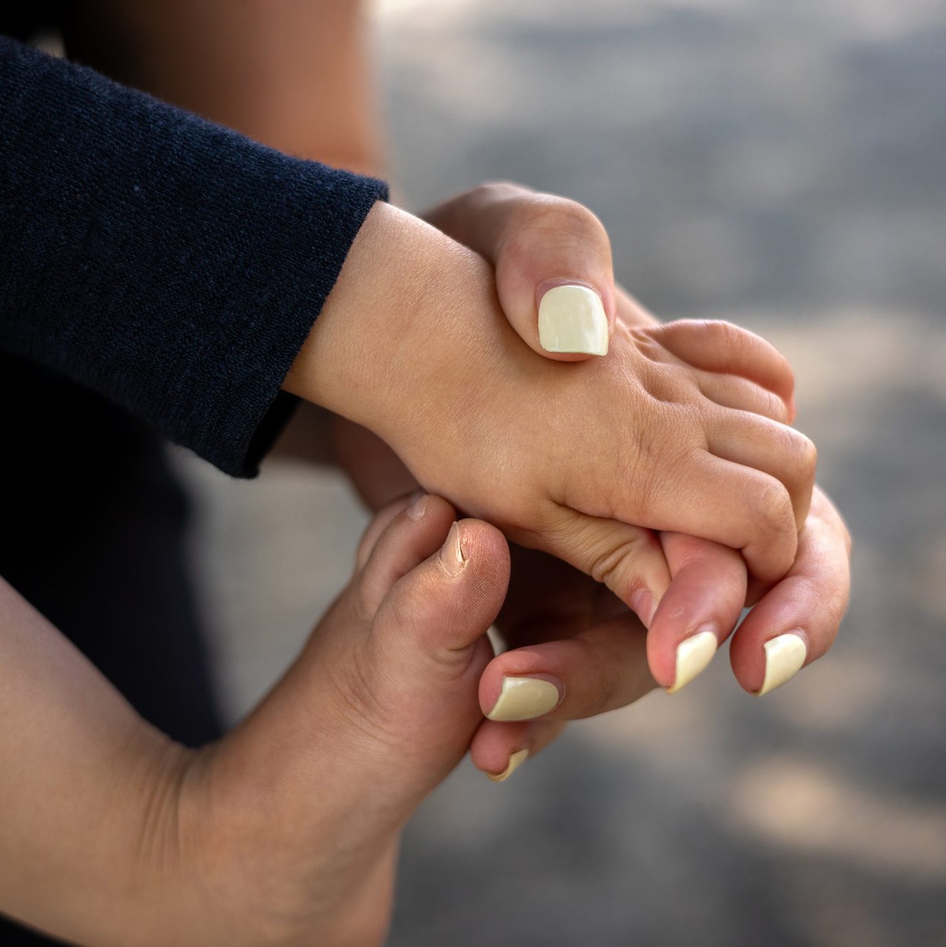 Mutterhand hält Babyfuss, geborgenheit