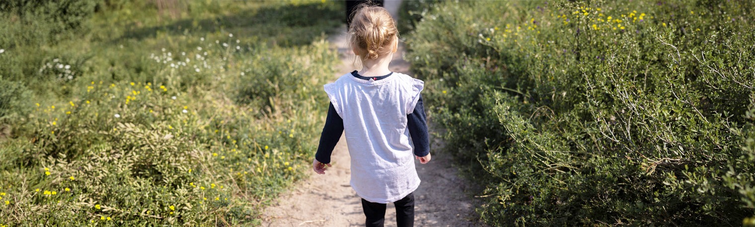 Kind laeuft einen Weg entlang, geborgen, wachsen